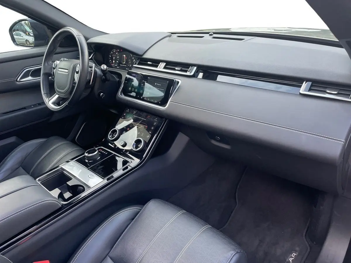 Intérieur noir du Range Rover Velar 2019, vue côté conducteur sur tableau de bord et console tactile moderne.