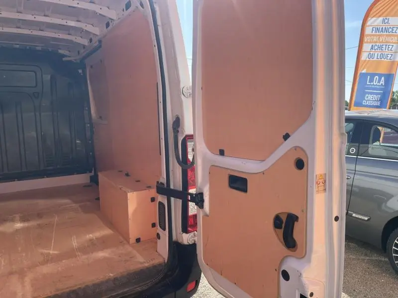 Vue intérieure arrière du Renault Master blanc glacier 2018 avec portes ouvertes et cloison en bois clair.