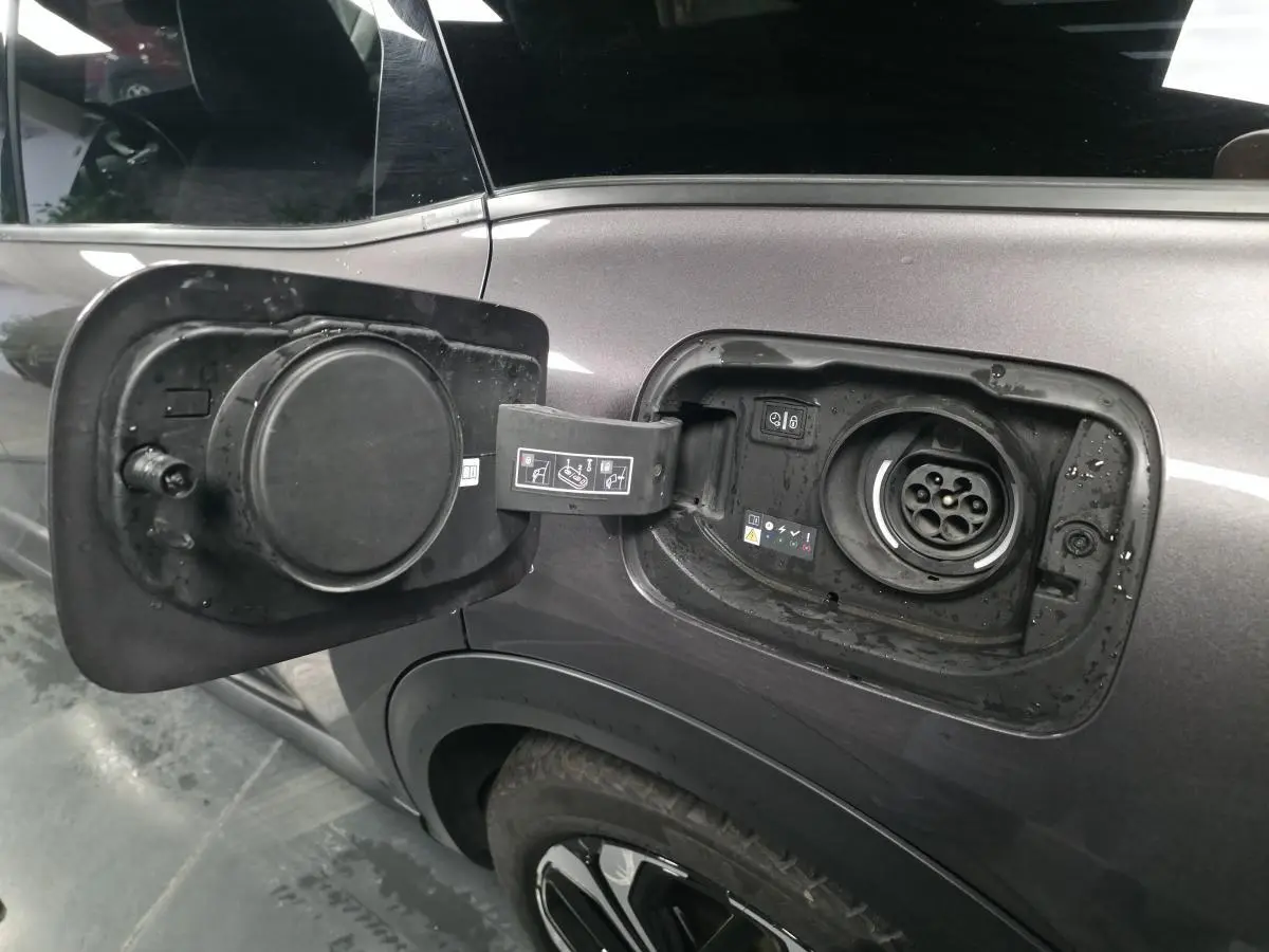 Trappe de recharge ouverte côté gauche sur Citroën C5 X hybride rechargeable gris métallisé avec jante alliage 19 pouces AeroX.