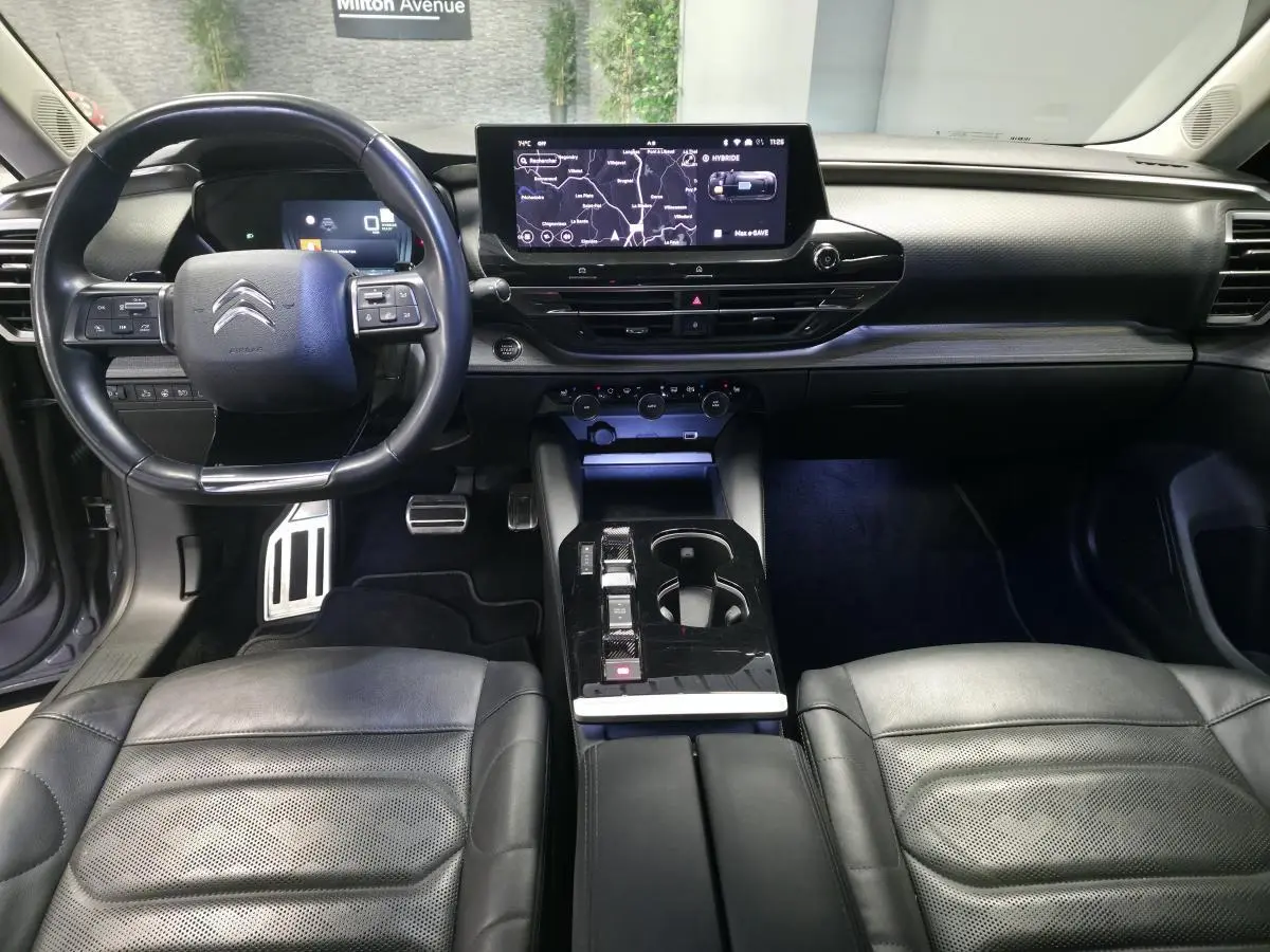 Intérieur noir cuir du Citroën C5 X Hybrid 2023, vue avant sur tableau de bord et console centrale moderne.