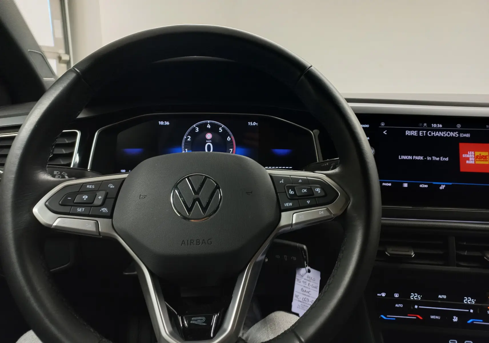 Vue rapprochée du volant noir de la Volkswagen Polo 2025 avec tableau de bord numérique et écran central allumé.