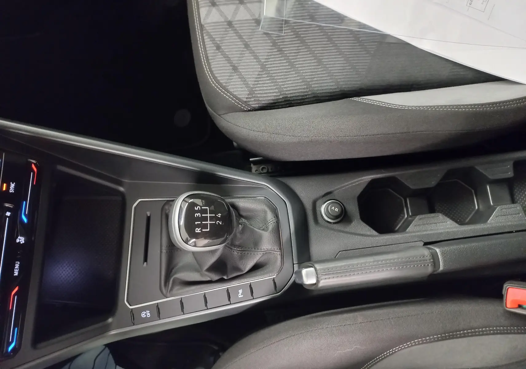Vue rapprochée de la console centrale de la Volkswagen Polo 1.0 TSI 95 BVM5 R-Line avec levier de vitesse manuel et frein à main.