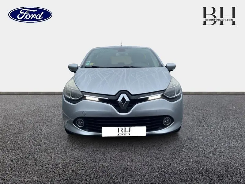 Vue frontale d'une Renault Clio gris platine avec feux LED allumés sur fond neutre.