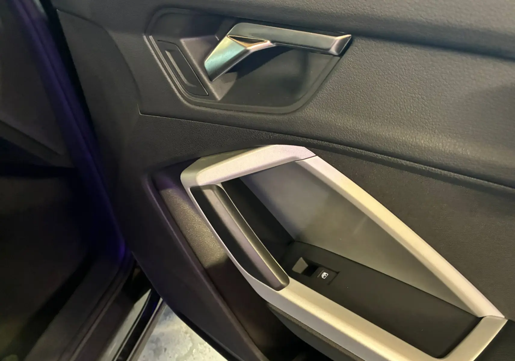 Vue rapprochée de la poignée intérieure côté gauche en plastique noir et argent de l'Audi Q3 Sportback 2022 noir.