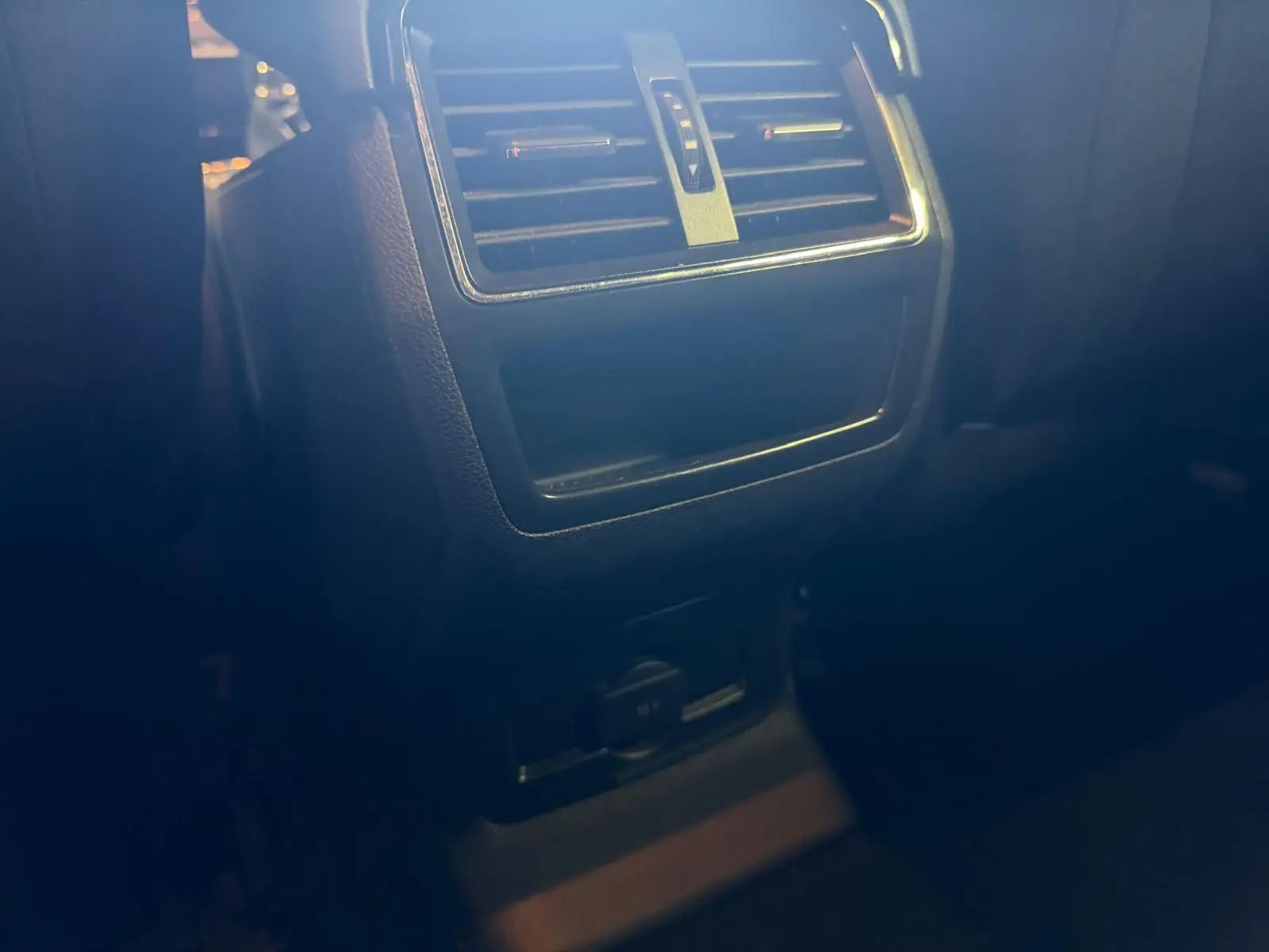 Détail de la console arrière avec bouches d'aération et prise 12V du Skoda Karoq blanc 2023, version 1.5 TSI Ambition.