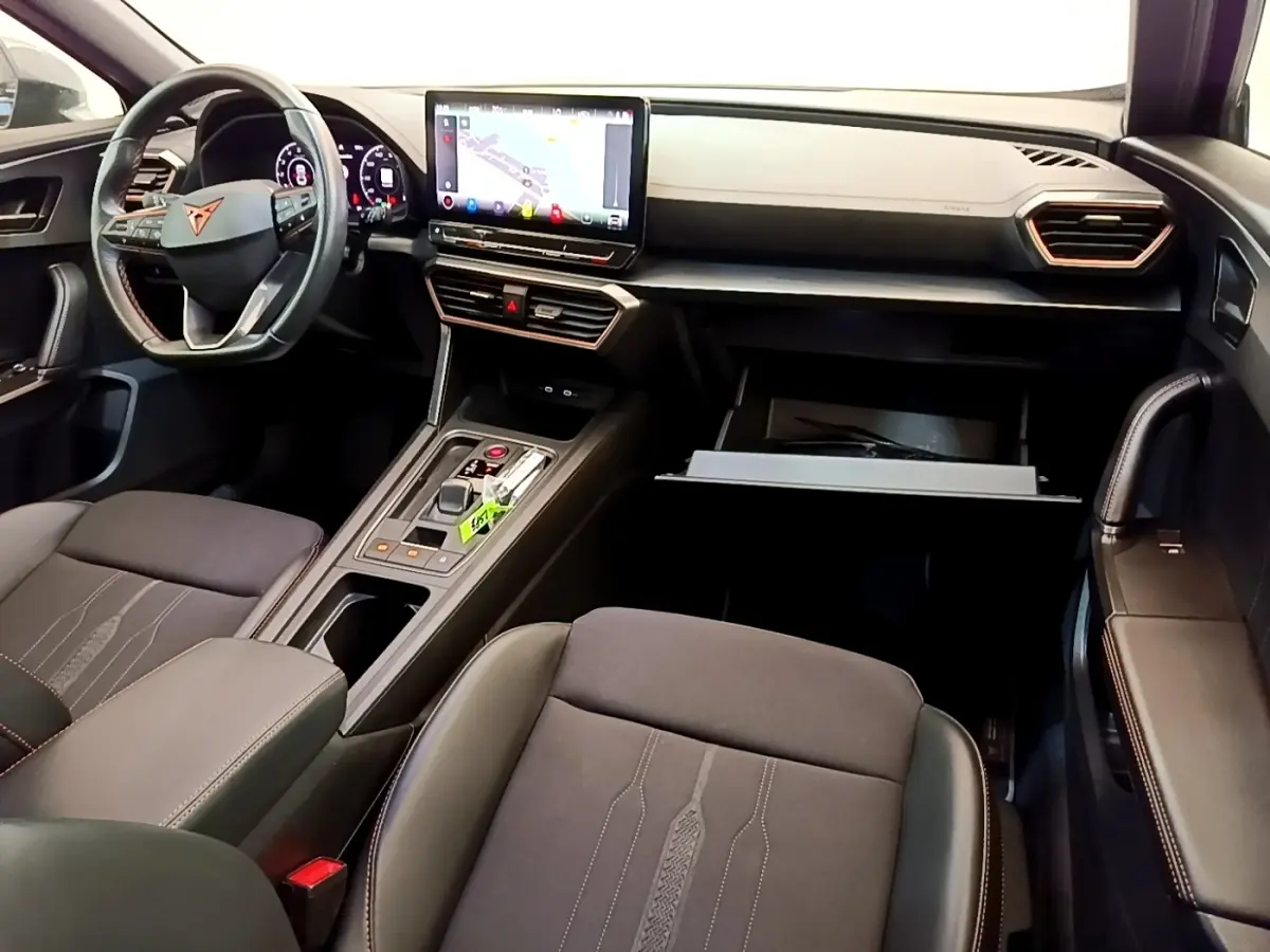 Intérieur avant de la CUPRA Formentor gris foncé, vue côté passager avec tableau de bord et écran tactile central visible.