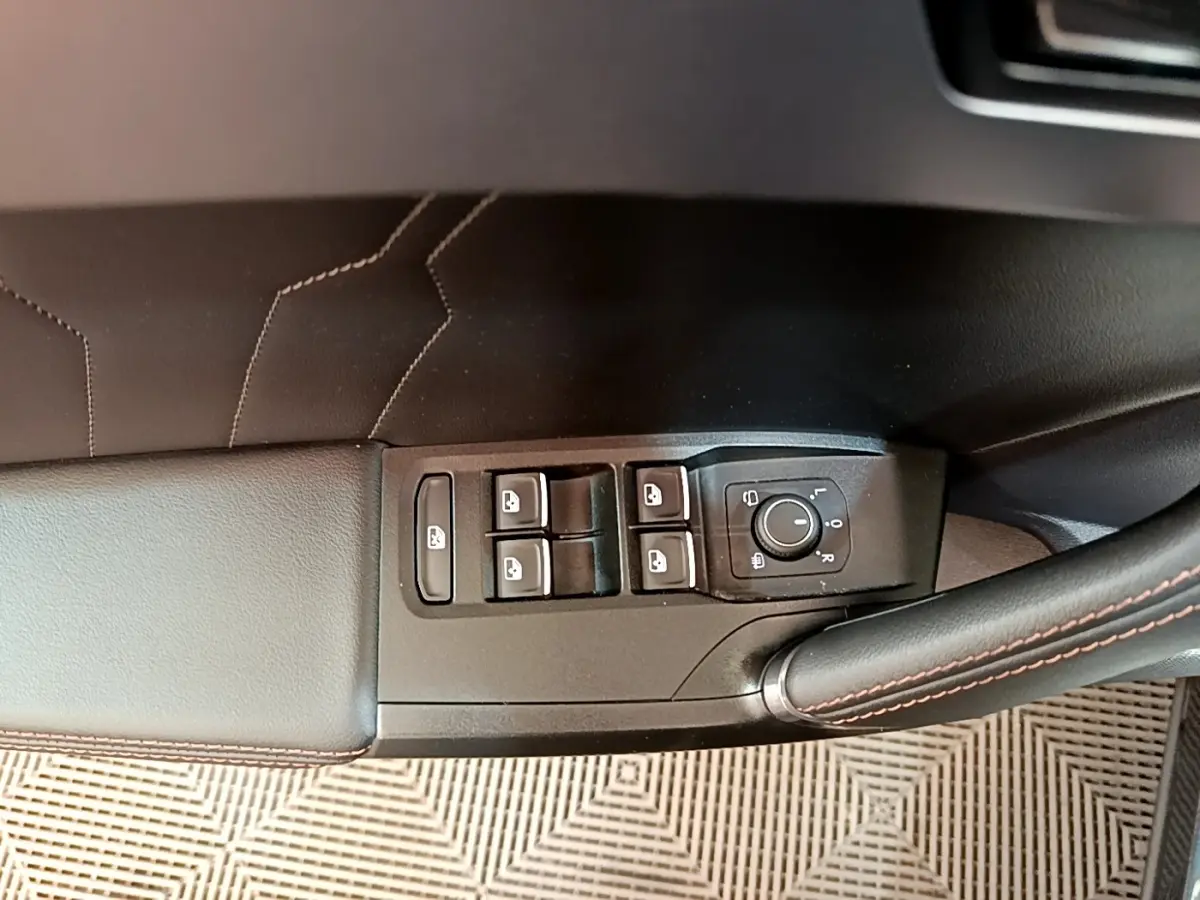 Détail des commandes de lève-vitres et réglage des rétroviseurs sur la porte côté conducteur d’une CUPRA Formentor gris foncé.