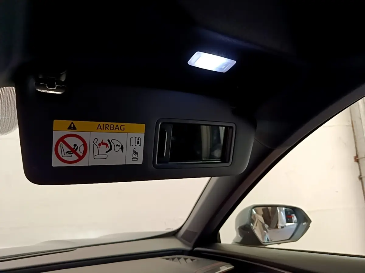 Détail intérieur du pare-soleil côté conducteur avec miroir et lumière allumée dans une CUPRA Formentor gris foncé.