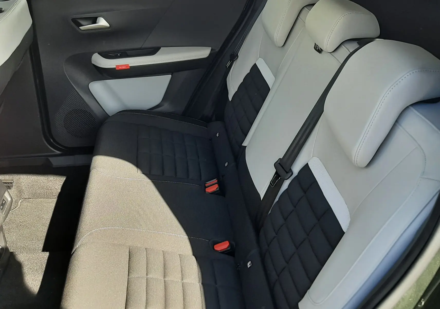 Vue intérieure arrière droite du Citroën C3 Aircross 2025, sièges bi-matière noir et gris avec surpiqûres.