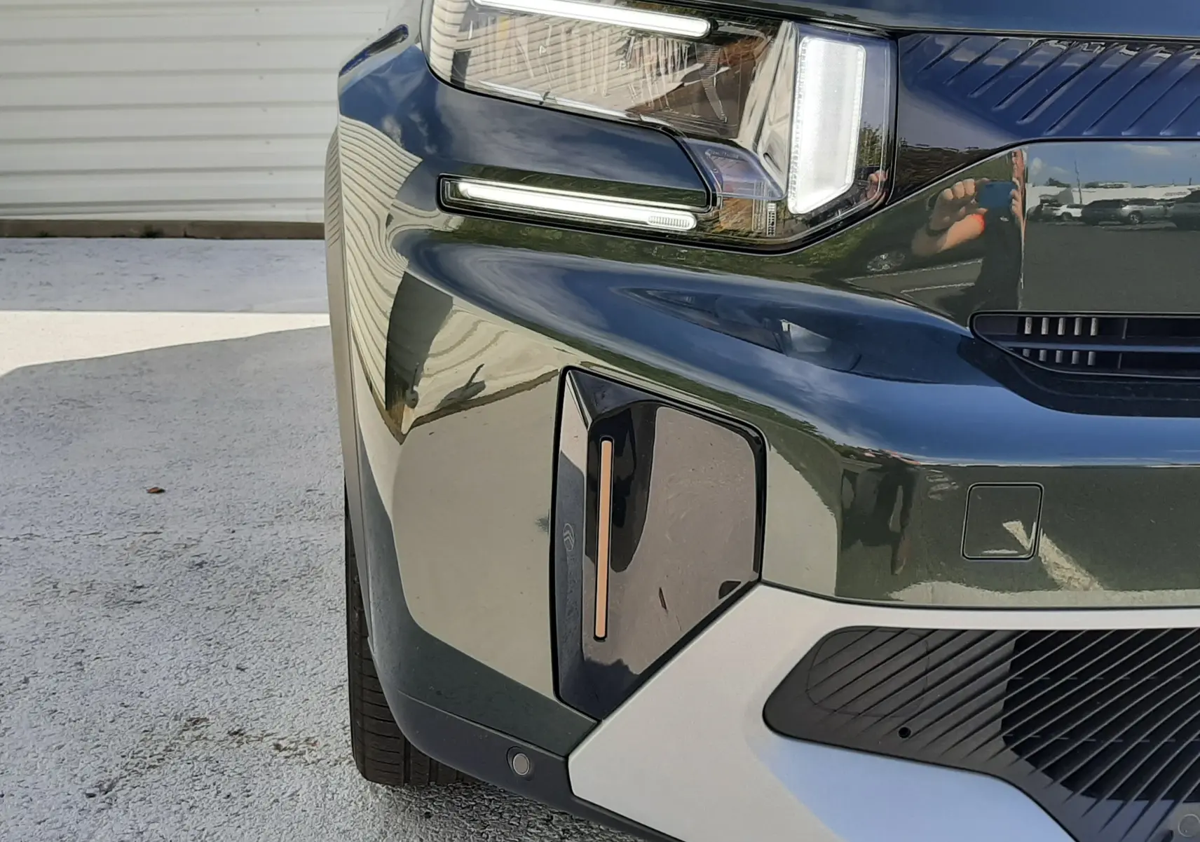 Gros plan sur l’avant droit du Citroën C3 Aircross 2025 vert Montana avec toit blanc, mettant en valeur ses phares LED distinctifs.