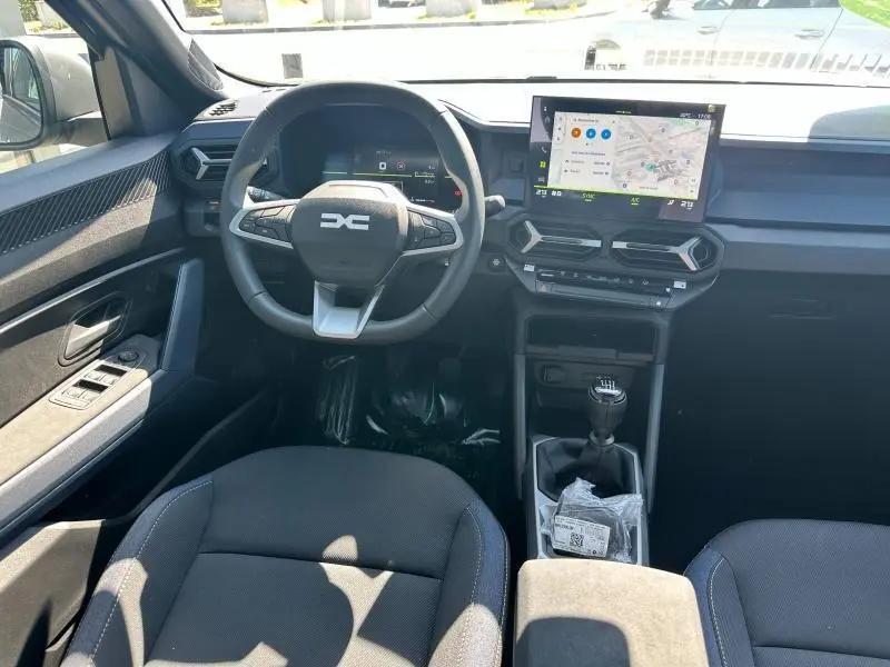Intérieur avant du Dacia Bigster blanc 2025, volant multifonction, écran tactile GPS et boîte manuelle visible