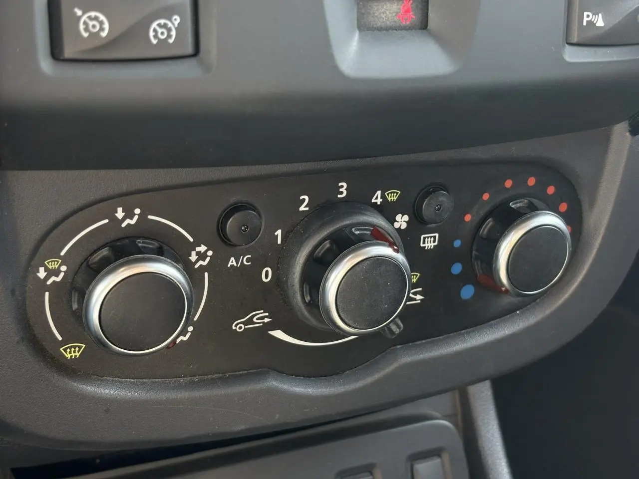 Commandes de climatisation manuelle du Dacia Duster TCE 125 Explorer, vue rapprochée du tableau de bord noir.