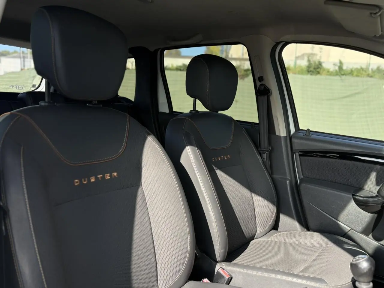 Vue intérieure des sièges avant noirs avec surpiqûres et logo DUSTER du Dacia Duster TCE 125 Explorer 2017.