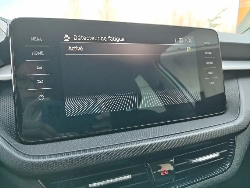 Écran tactile central de la Skoda Fabia 2023 montrant l'activation du détecteur de fatigue, intérieur noir et gris.