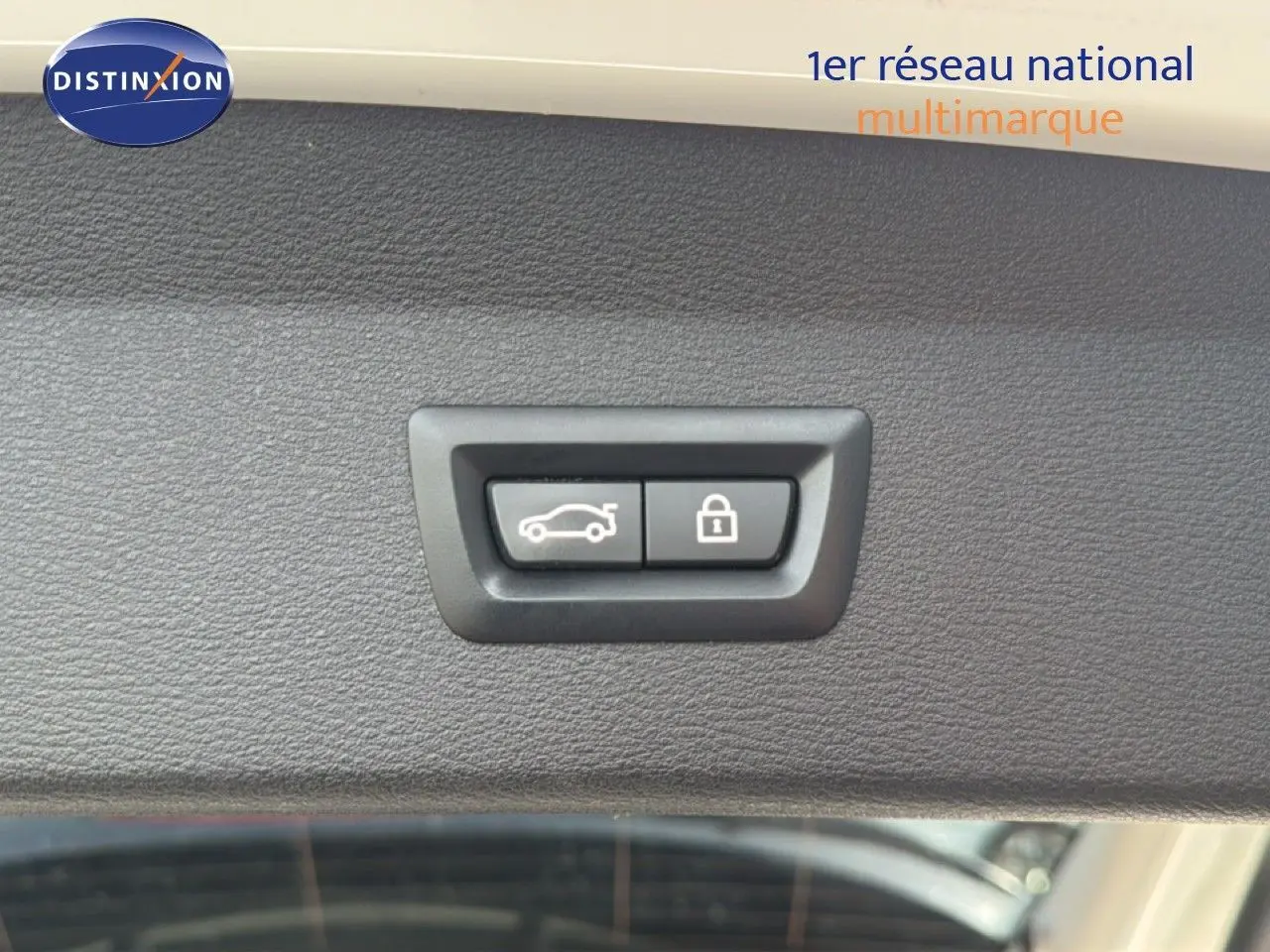 Gros plan sur les boutons d'ouverture de coffre et de verrouillage, intérieur d'un BMW X1 blanc de 2022.