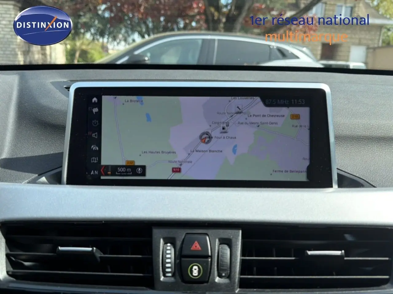Vue intérieure centrée sur l'écran tactile du système de navigation du BMW X1 blanc, version 2022.