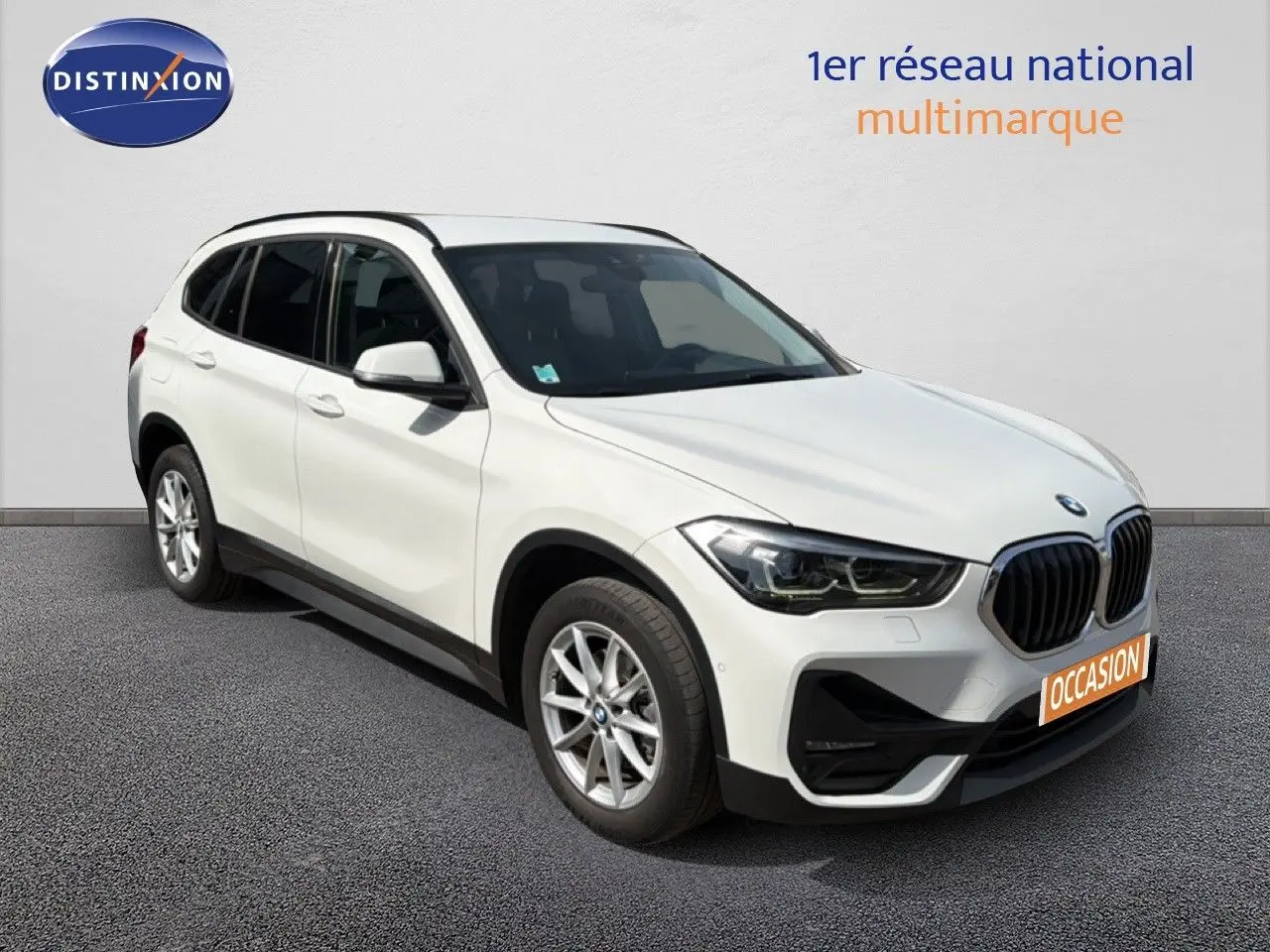BMW X1 blanc en vue 3/4 avant droit, avec calandre noire et jantes alliage 17 pouces visibles.
