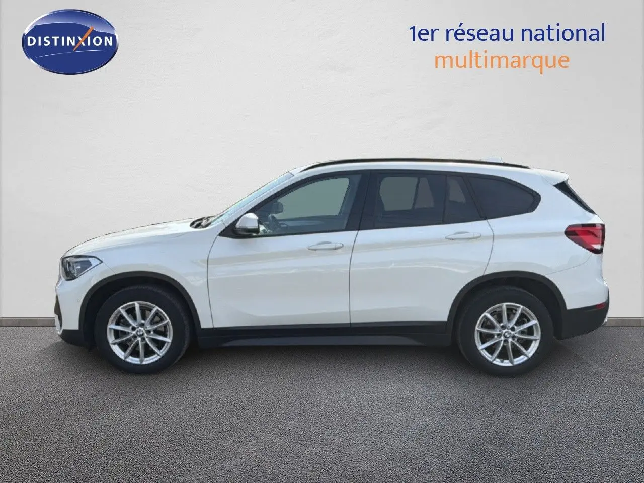 BMW X1 blanc vue de profil côté gauche sur fond neutre, soulignant ses lignes modernes et ses jantes alliage.