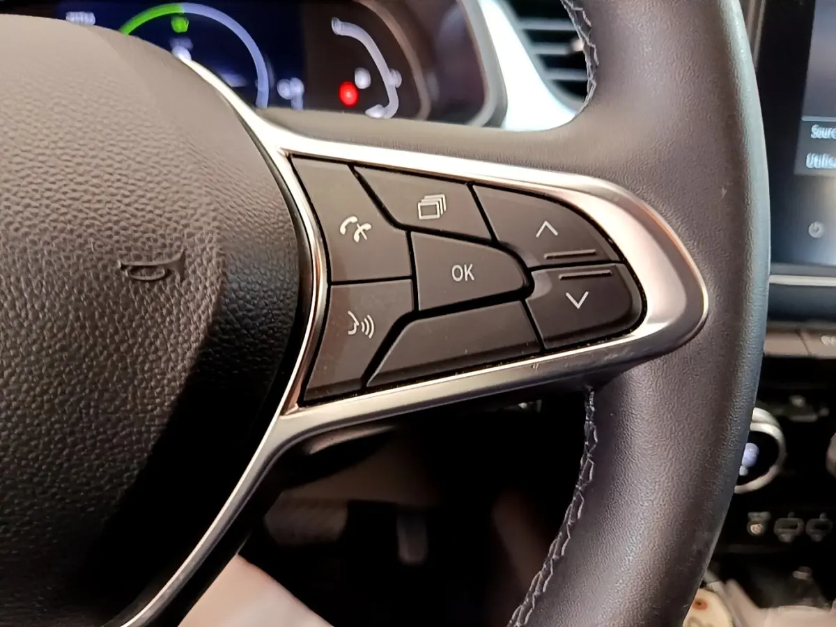 Gros plan sur les commandes multifonctions à droite du volant cuir noir du Renault Captur Zen E-Tech hybride 2022.