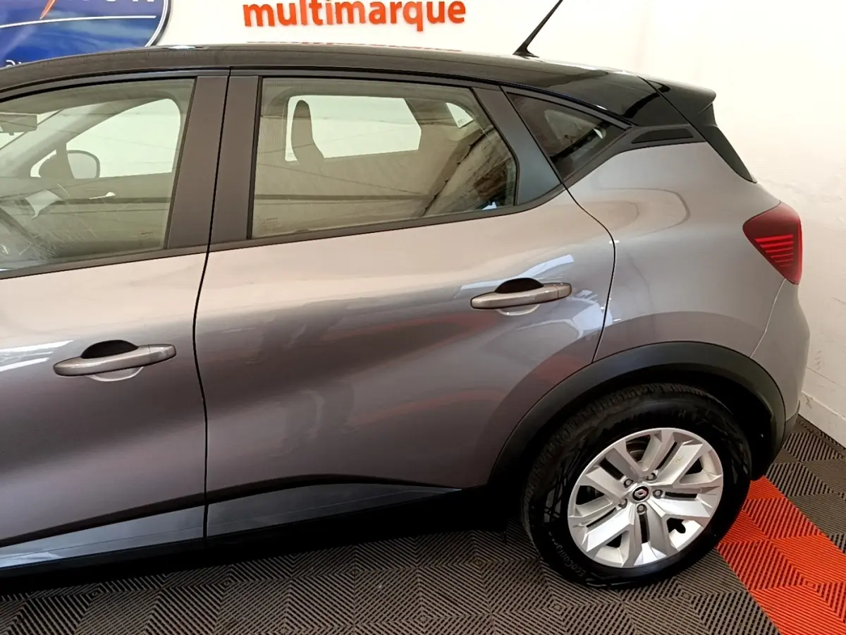 Vue latérale droite du Renault Captur Zen E-Tech hybride gris foncé, mettant en valeur la porte arrière et la roue arrière.