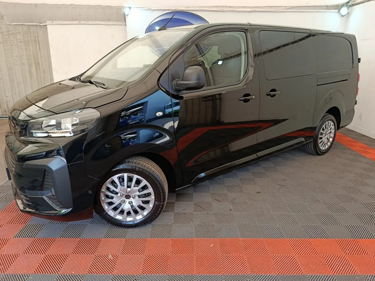 Vue 3/4 avant droit du Peugeot Expert Fourgon XL noir, avec jantes alliage et rétroviseurs noirs, dans un showroom.