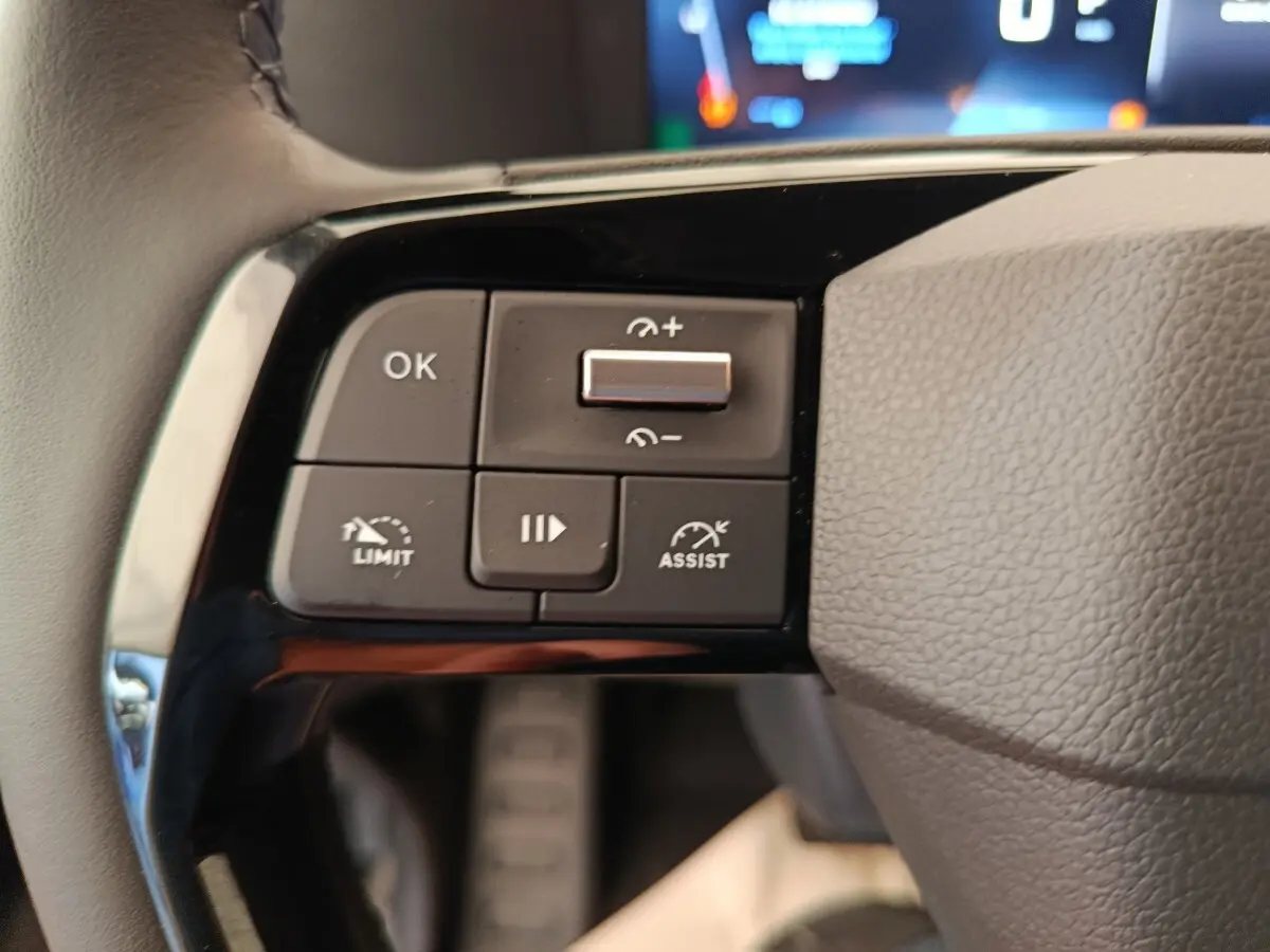 Gros plan sur les commandes de régulateur de vitesse au volant gris du Peugeot Expert Fourgon XL noir.