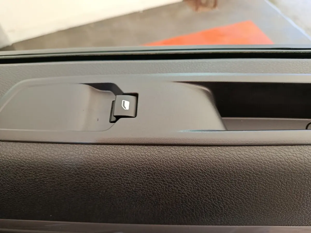 Gros plan sur le bouton de commande de vitre électrique sur la porte intérieure d’un Peugeot Expert Fourgon noir.