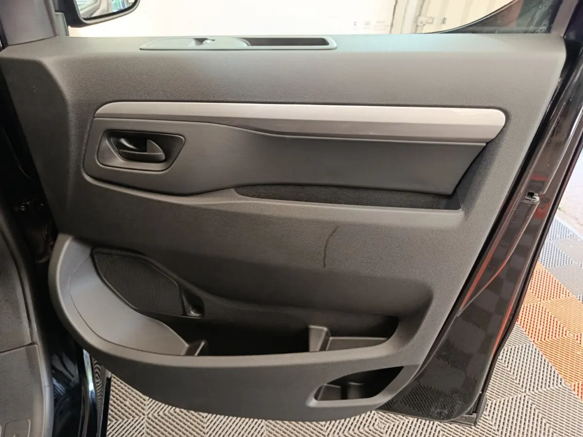 Vue rapprochée de la porte côté gauche noire du Peugeot Expert Fourgon XL 2026, avec poignée et rangement intégré.