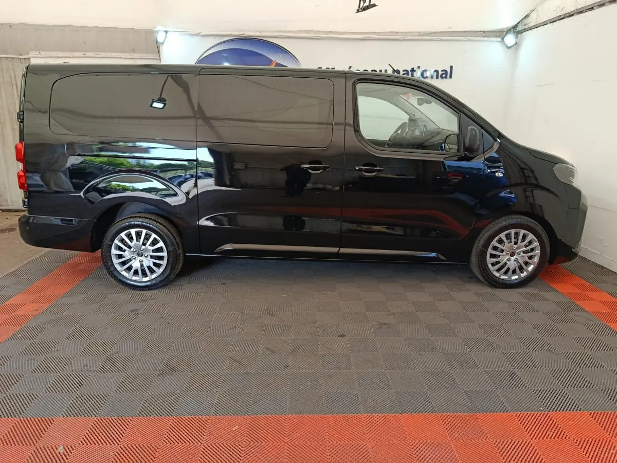 Vue latérale droite du fourgon Peugeot Expert XL noir, avec jantes alliage et portes coulissantes fermées.