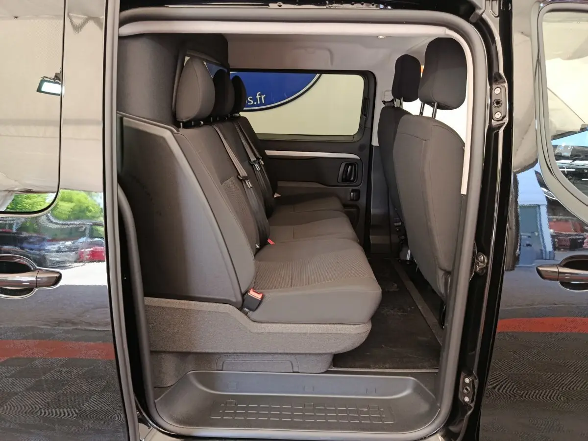 Vue latérale intérieure du Peugeot Expert Fourgon XL noir, montrant la banquette arrière 3 places en tissu gris.