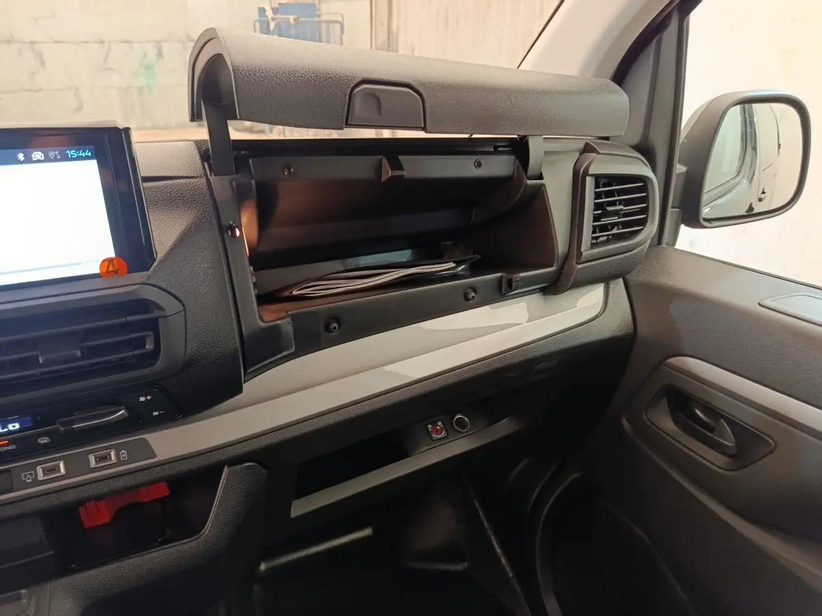 Intérieur du Peugeot Expert Fourgon XL 2026, vue côté passager avec boîte à gants ouverte et tableau de bord noir et gris.