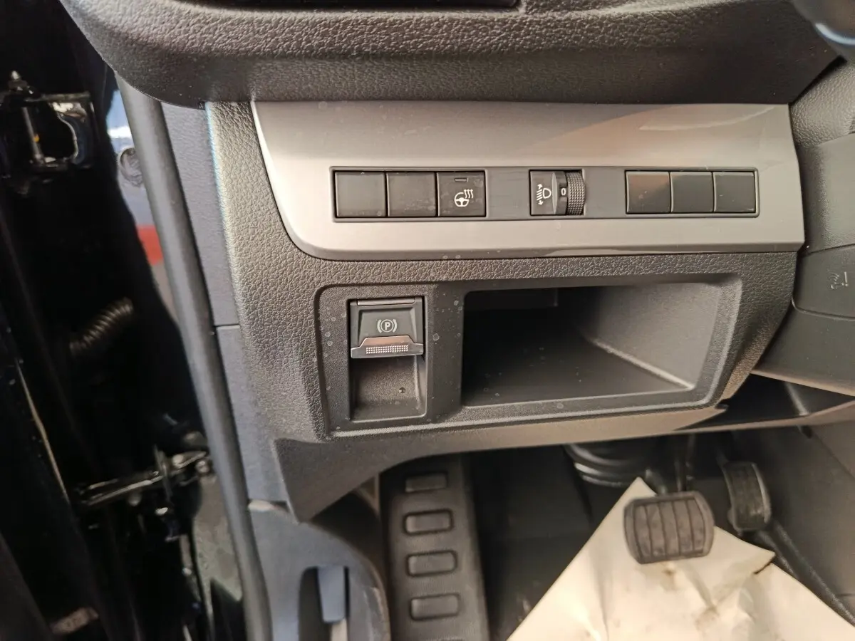 Gros plan sur la console inférieure côté conducteur du Peugeot Expert Fourgon noir, avec commandes et pédales visibles.