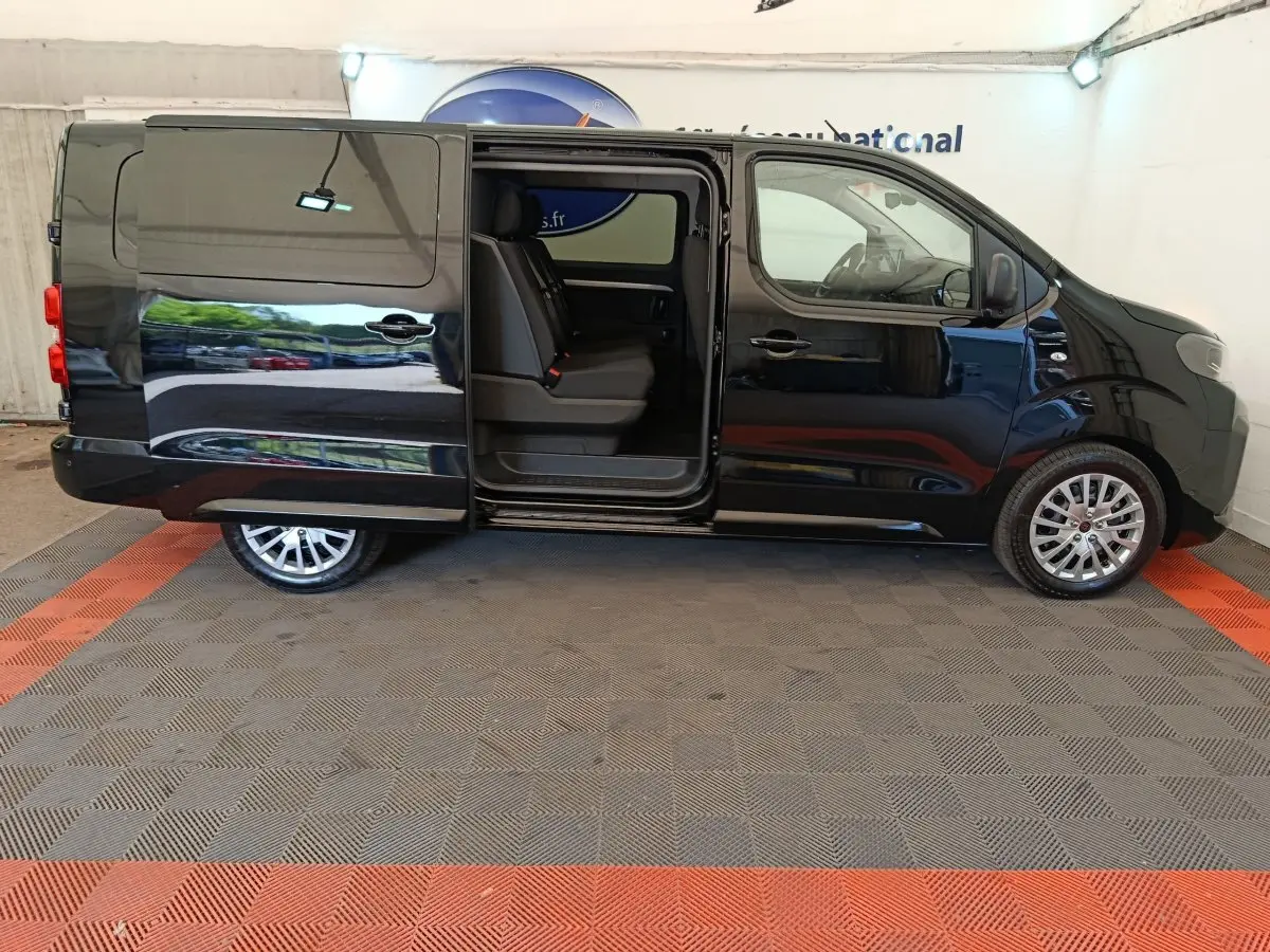 Vue latérale droite d’un Peugeot Expert Fourgon XL noir avec porte coulissante ouverte dévoilant les sièges arrière.