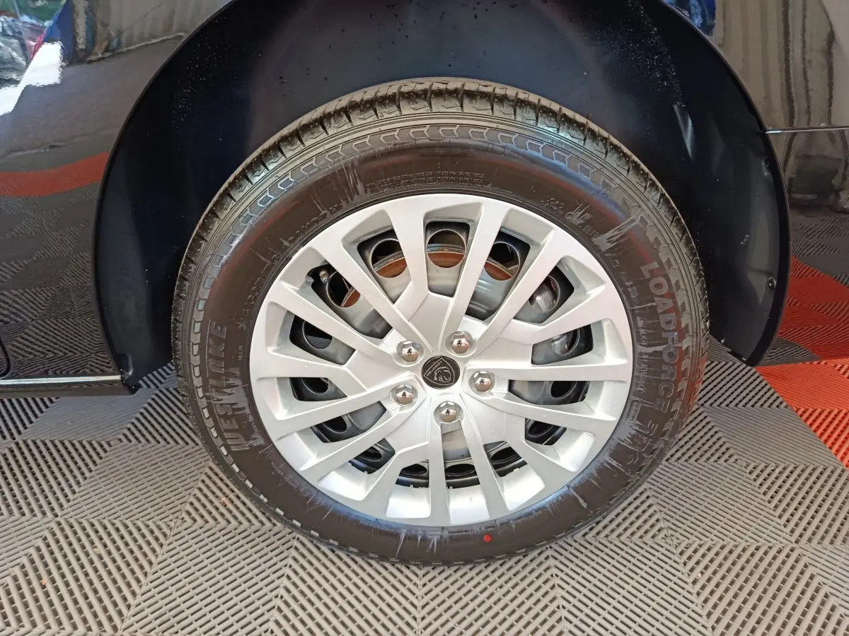 Gros plan sur la roue avant gauche noire du Peugeot Expert Fourgon XL Diesel 2026 avec jante argentée et logo Peugeot central.
