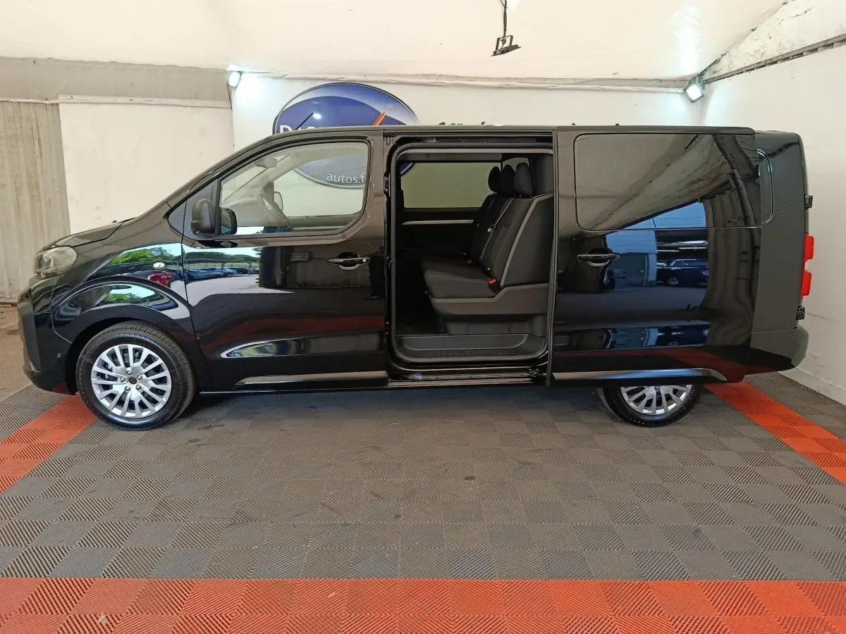 Vue latérale gauche d'un Peugeot Expert Fourgon XL noir avec porte coulissante ouverte montrant la banquette arrière trois places.