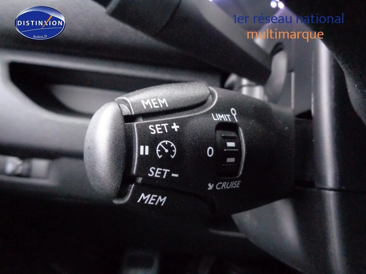 Vue intérieure côté conducteur du Peugeot Expert gris avec sièges tissu gris et noir, volant et ceintures visibles.