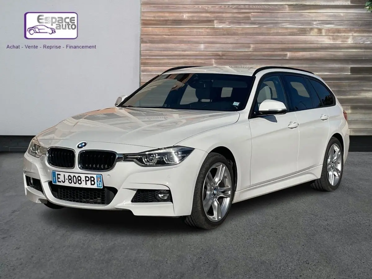 BMW Série 3 Touring F31 blanc vue 3/4 avant droit, avec jantes alliage et calandre noire M Sport visible