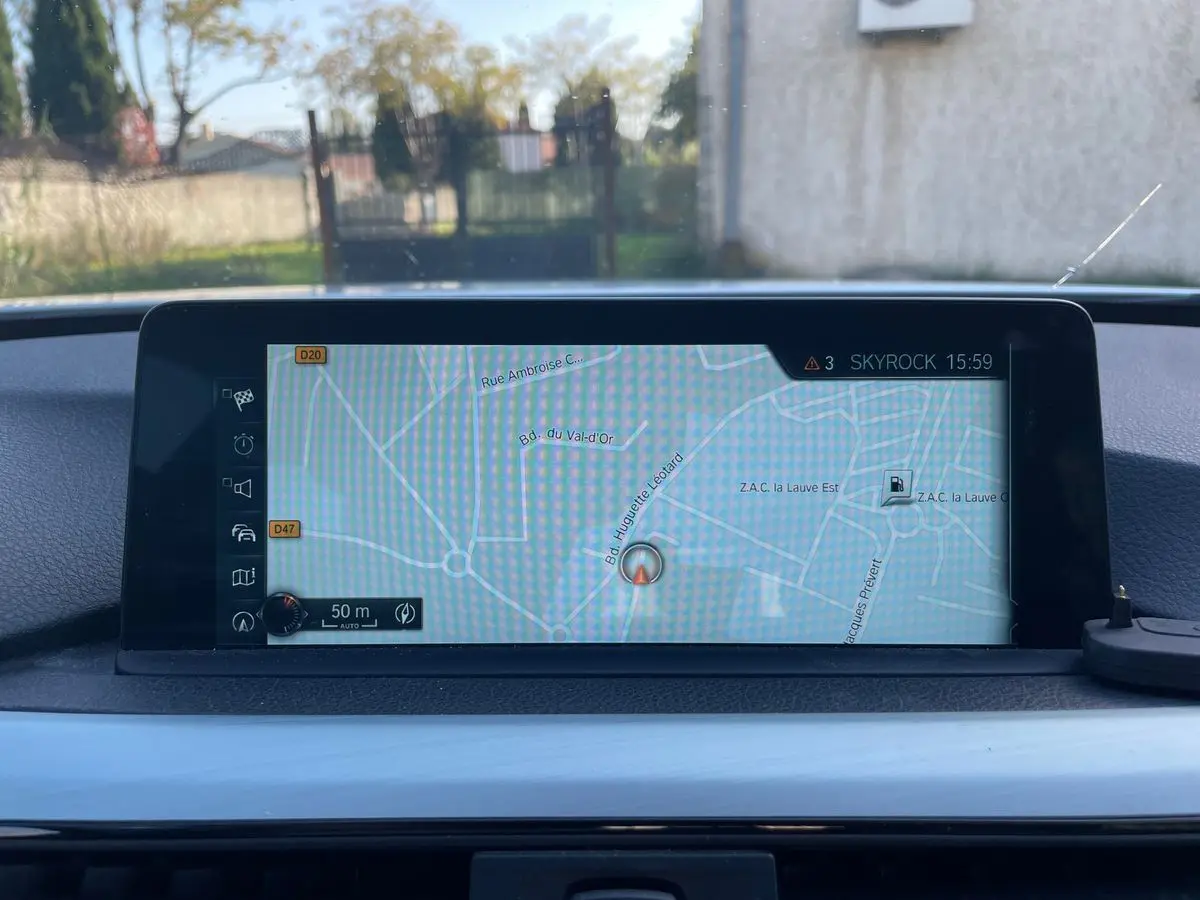 Écran de navigation GPS allumé sur le tableau de bord d'une BMW Série 3 Touring F31 blanche, vue intérieure.