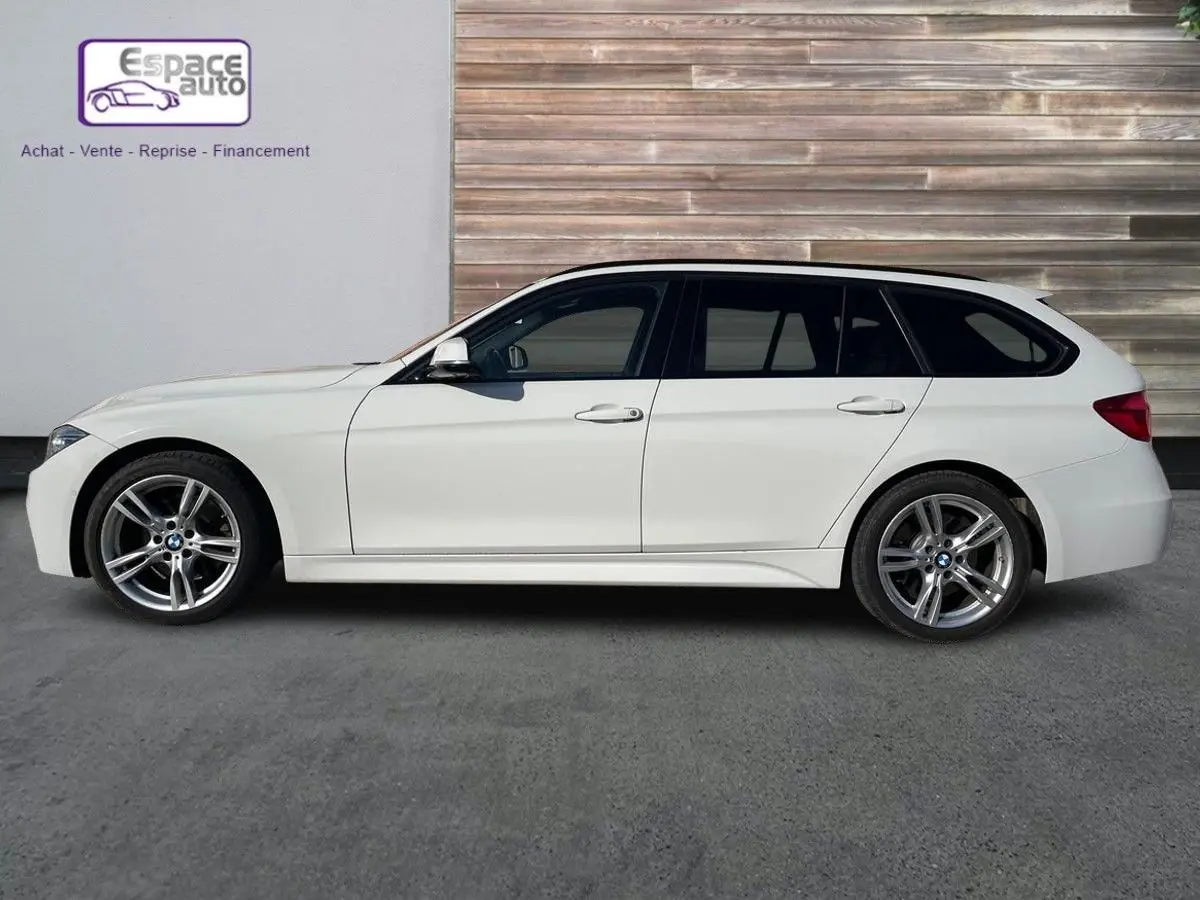 BMW Série 3 Touring F31 blanc vue de profil côté gauche, avec jantes alliage et finition M Sport visible.