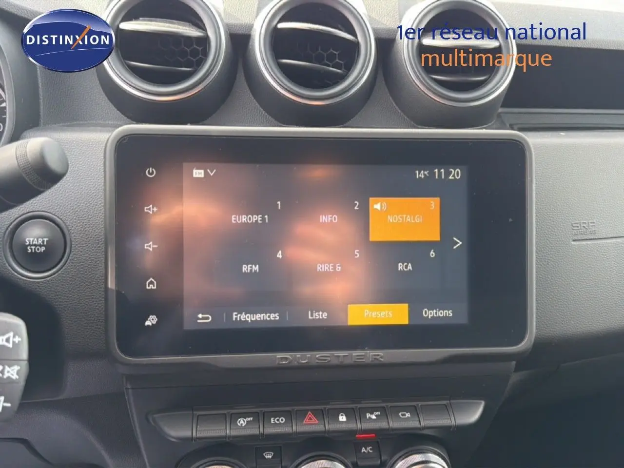 Vue rapprochée de l’écran tactile central du Dacia Duster 2022 avec commandes et aérateurs ronds noirs.