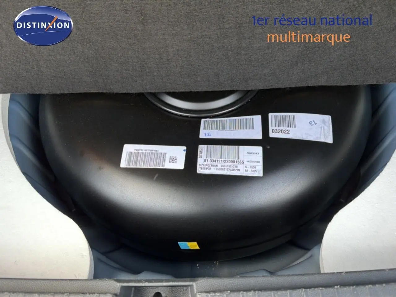 Vue rapprochée du réservoir GPL noir installé dans le coffre du Dacia Duster bleu Iron 2022.