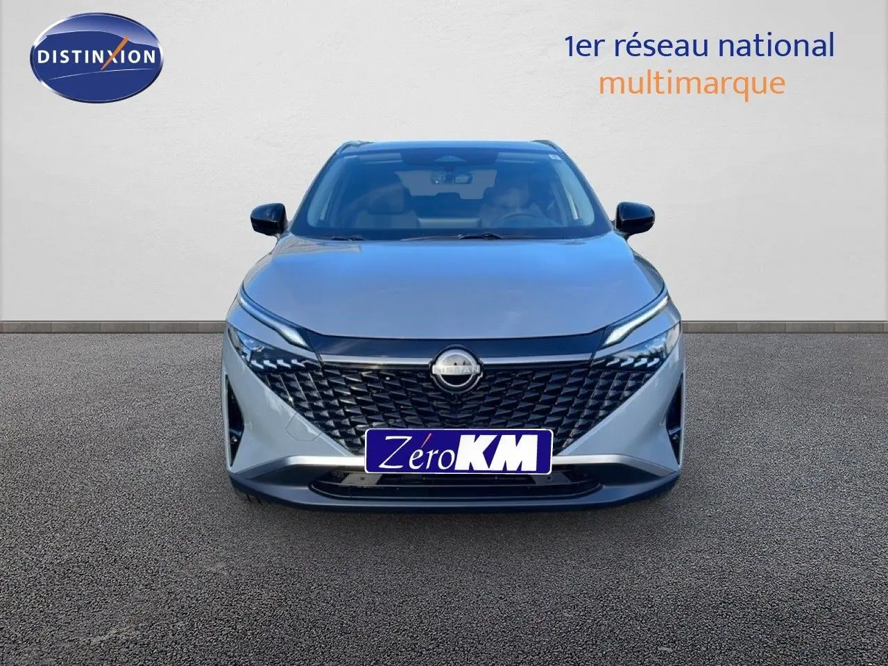 Vue avant d'un Nissan Qashqai 2025 gris argile métal avec calandre noire et phares LED fins.