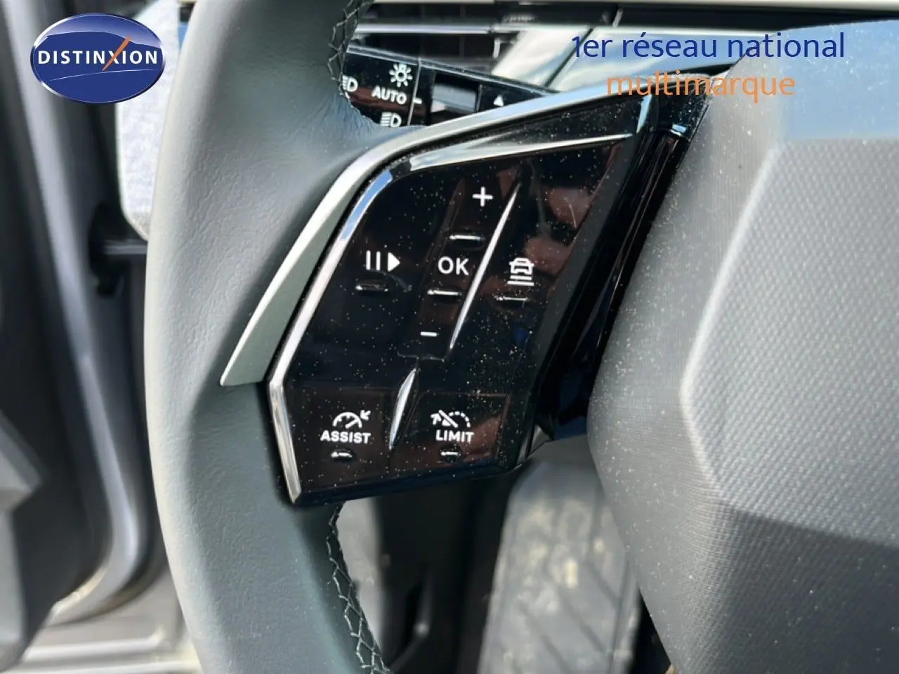 Gros plan sur les commandes noires au volant gris du Peugeot 5008 1.2 Hybrid 145ch Allure 2025.