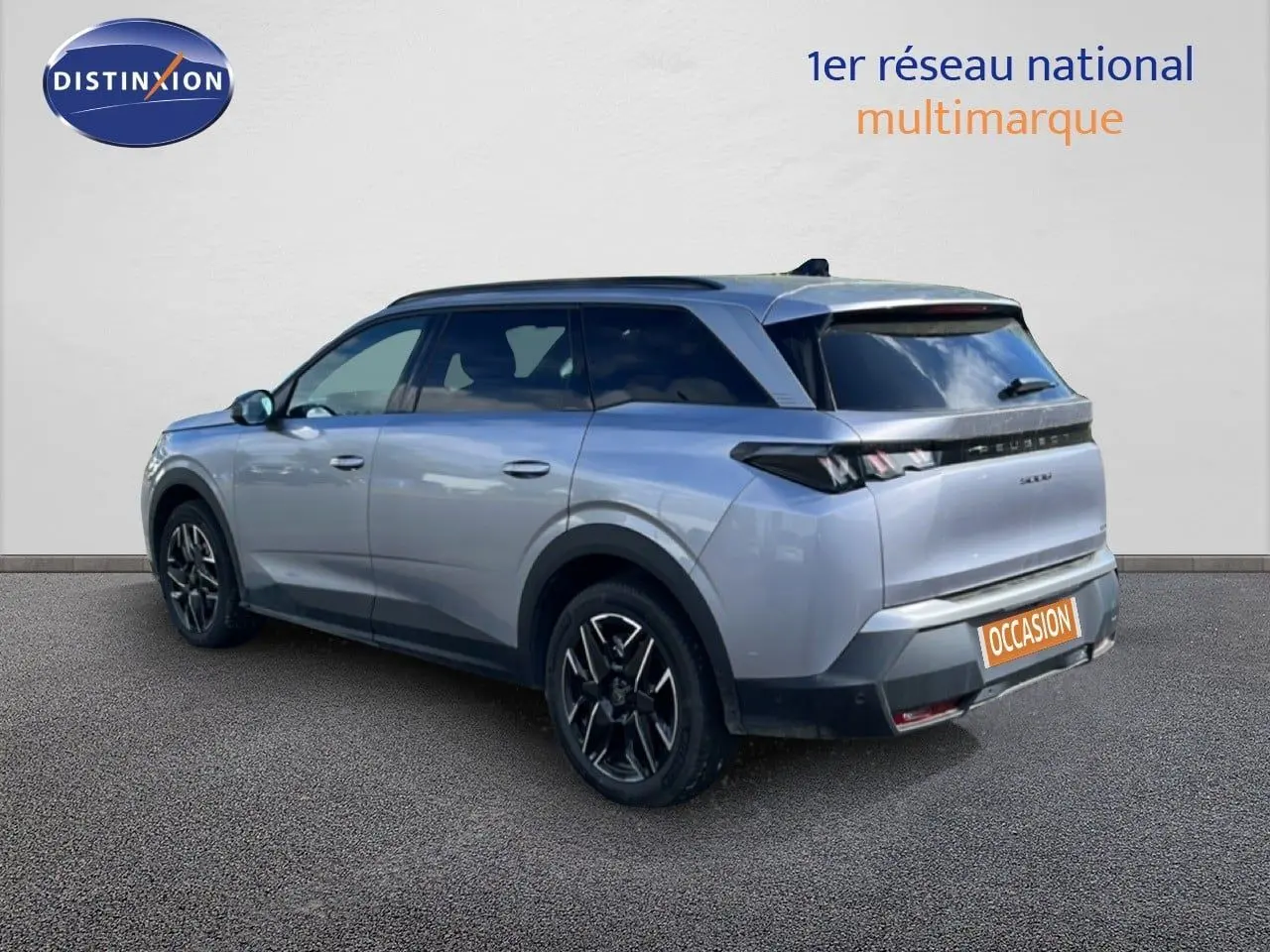 Peugeot 5008 gris Artense métal en 3/4 arrière droit, avec jantes noires et toit panoramique visible.