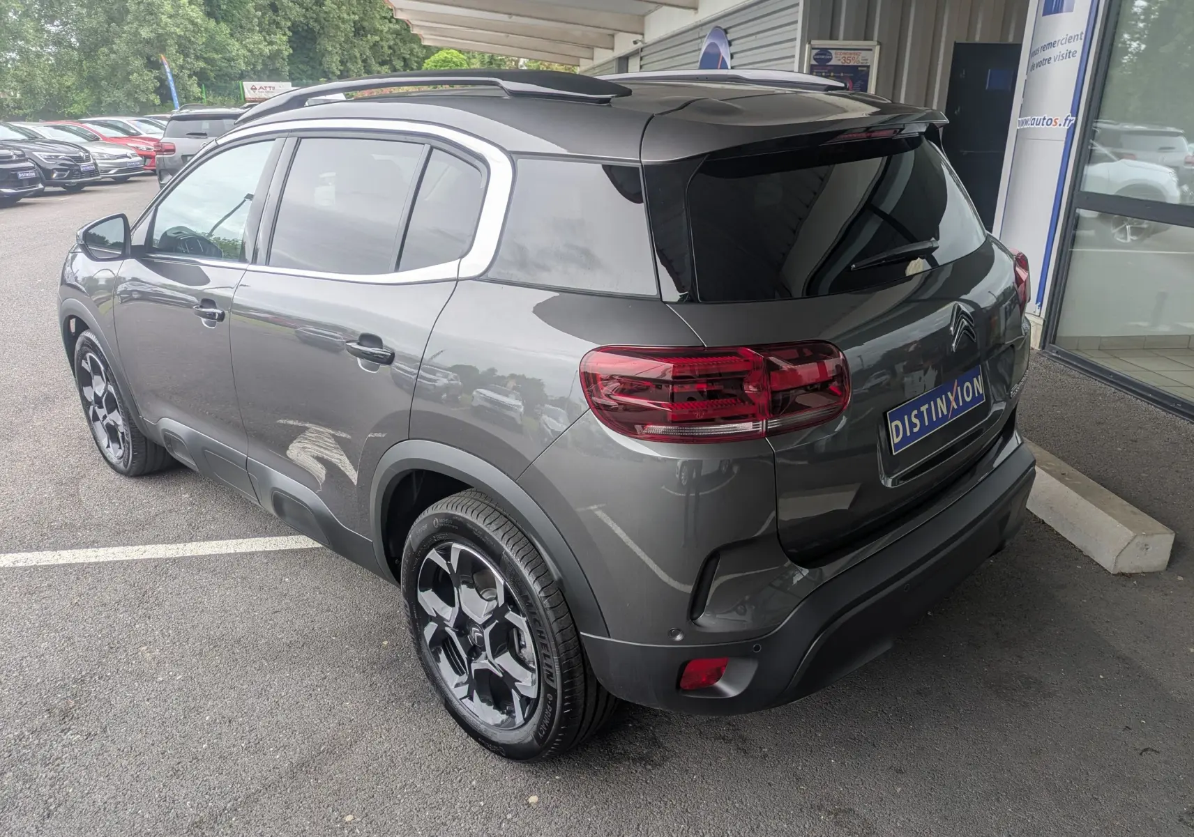 Vue 3/4 arrière droite du Citroën C5 Aircross hybride gris platinium avec jantes alliage biton et vitres arrière surteintées.
