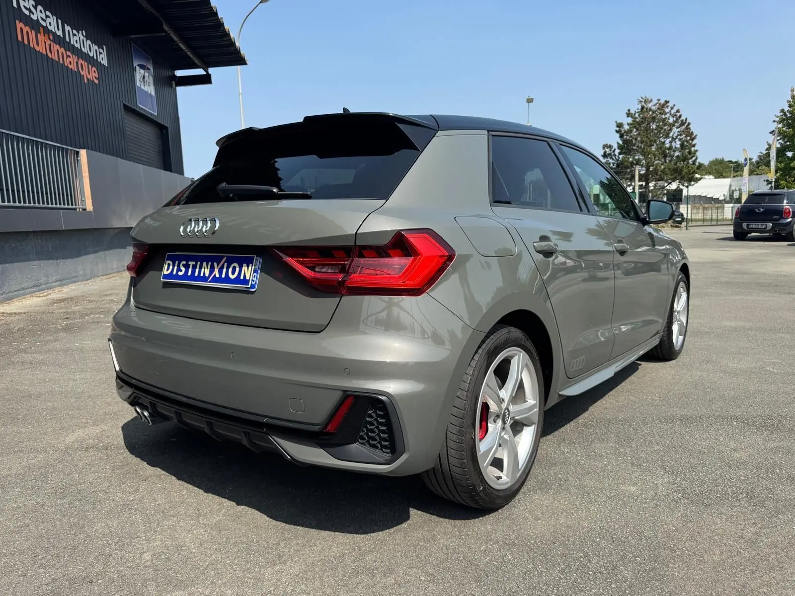 Audi A1 Sportback gris vue 3/4 arrière droit, avec jantes sport et feux arrière LED distinctifs.