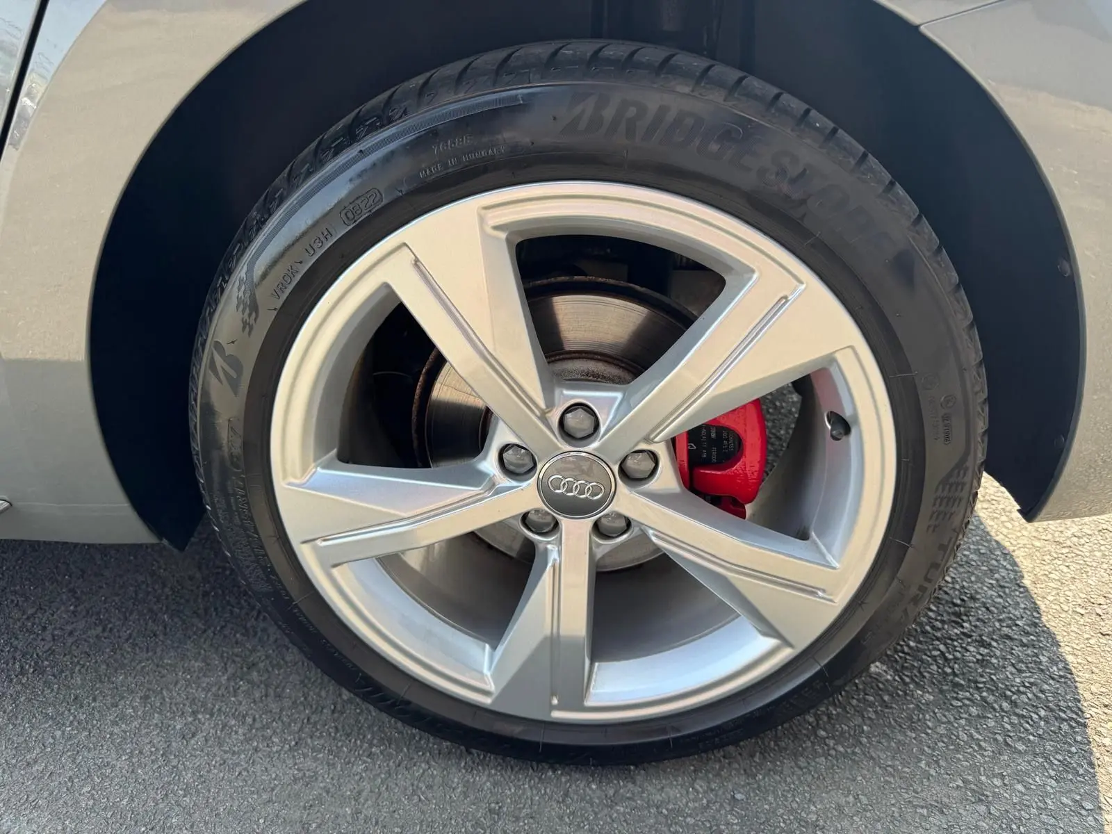 Gros plan sur la roue avant droite grise d'une Audi A1 Sportback 2019 avec étrier de frein rouge et jante alu cinq branches.