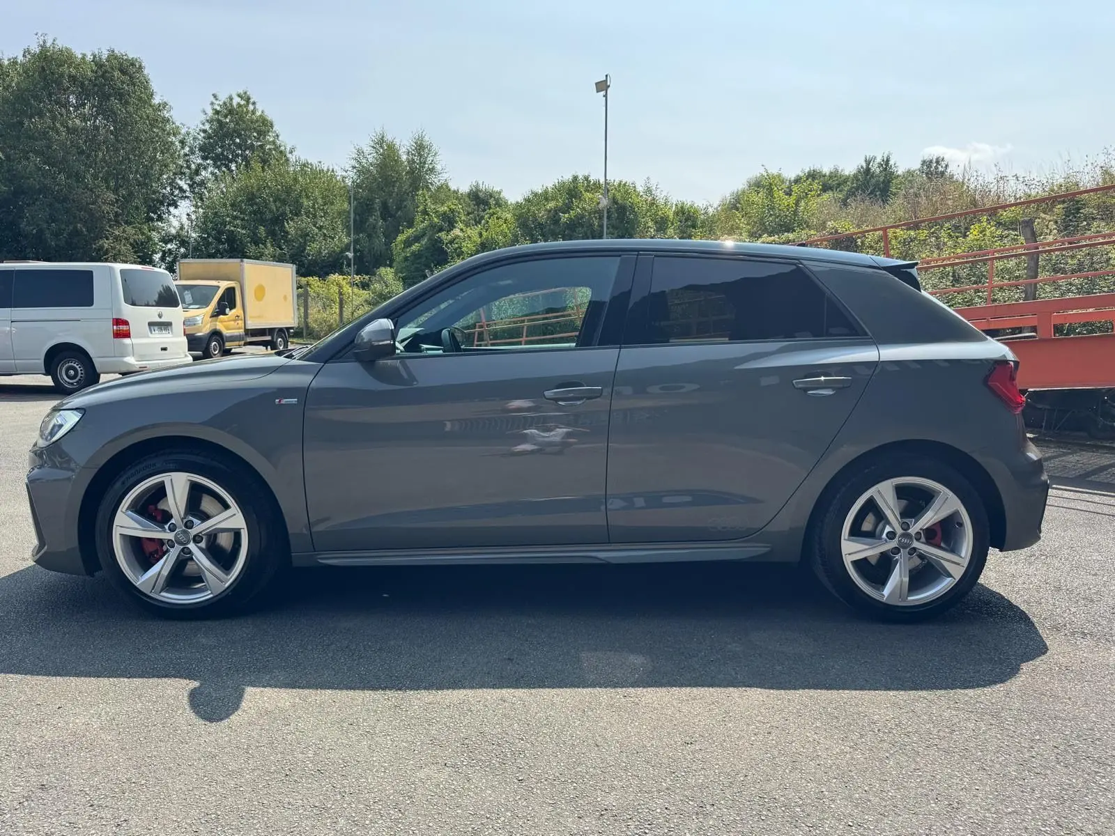 Profil côté gauche d'une Audi A1 Sportback gris métallisé de 2019 avec jantes alliage et étriers rouges.