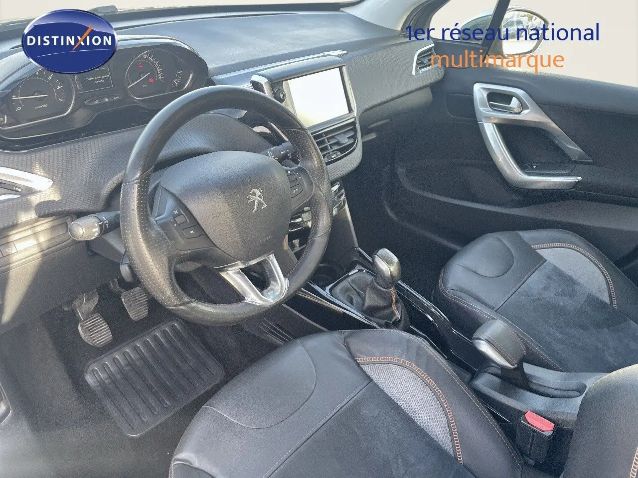 Vue intérieure côté conducteur du Peugeot 2008 gris platinium, avec volant cuir et console centrale équipée d'un écran tactile.