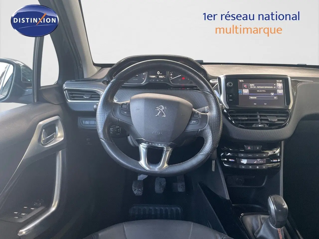 Vue intérieure centrée sur le volant et tableau de bord du Peugeot 2008 gris platinium de 2019.